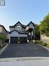 View of front of property with stucco siding, driveway, an attached garage, and stone siding - 11 Donatello Court, Hamilton, ON  - Outdoor With Facade 