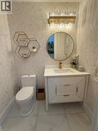 Bathroom featuring wallpapered walls, vanity, and light marble finish floors - 