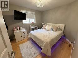 Bedroom featuring a textured ceiling, light wood-style flooring, and a chandelier - 
