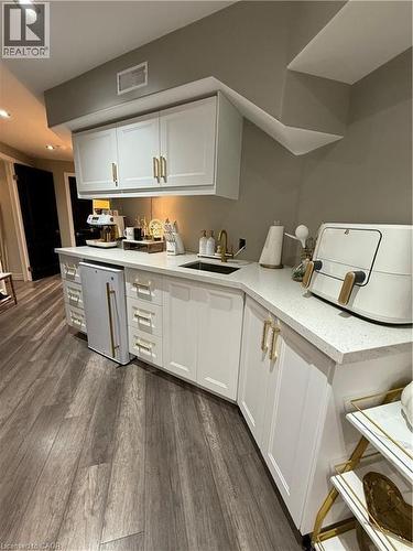 Kitchen featuring white cabinets, dark wood finished floors, recessed lighting, light stone countertops, and fridge - 11 Donatello Court, Hamilton, ON - Indoor Photo Showing Kitchen