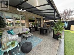 Fenced backyard with a ceiling fan, outdoor dining space, outdoor lounge area, and a patio area - 