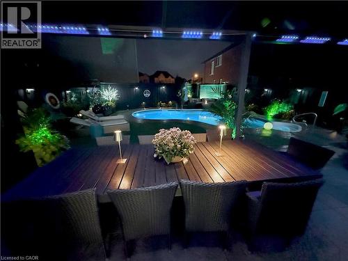 Pool at night with a deck and a patio area - 11 Donatello Court, Hamilton, ON -  With In Ground Pool