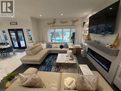 Living area with a glass covered fireplace, french doors, and recessed lighting - 