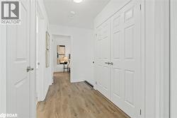 Hall featuring light wood-style floors and a textured ceiling - 