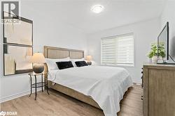 Bedroom with light wood-type flooring and a textured ceiling - 