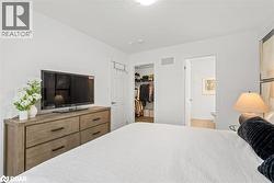 Bedroom featuring a walk in closet, ensuite bathroom, and a textured ceiling - 