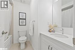 Full bathroom with vanity, light tile patterned floors, and shower / bath combo - 