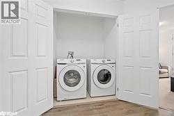Laundry area featuring wood finished floors and separate washer and dryer - 