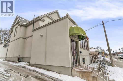 View of snow covered exterior with stucco siding - 612 King Street E, Kitchener, ON 