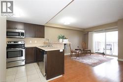 View of Kitchen with a peninsula with breakfast bar creating visual separation from living room while maintaining open concept vibe. - 