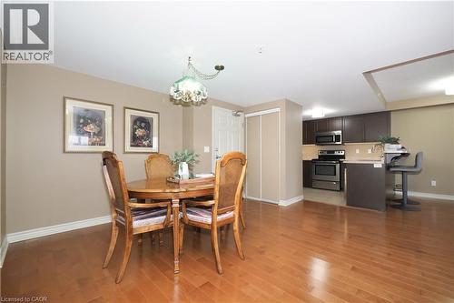 Dining space featuring a chandelier and classic hardwood flooring. - 645 St. David Street S Unit# 412, Fergus, ON - Indoor Photo Showing Dining Room