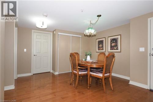 Dining room with a chandelier and classic hardwood floors. - 645 St. David Street S Unit# 412, Fergus, ON - Indoor Photo Showing Dining Room