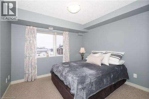 Primary bedroom featuring light colored berber carpet. - 645 St. David Street S Unit# 412, Fergus, ON - Indoor Photo Showing Bedroom