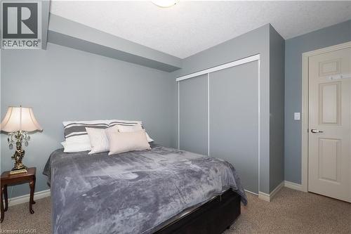 Bright primary bedroom featuring beautiful berber carpeting, and a spacious closet. - 645 St. David Street S Unit# 412, Fergus, ON - Indoor Photo Showing Bedroom