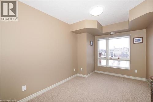 Unfurnished second bedroom with large windows and quality berber carpeting. - 645 St. David Street S Unit# 412, Fergus, ON - Indoor Photo Showing Other Room