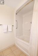 Full bathroom with light ceramic tile flooring and premium acrylic shower / bath combination. - 