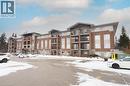 Winter view of building from far side of outdoor parking area - 645 St. David Street S Unit# 412, Fergus, ON  - Outdoor With Balcony With Facade 