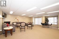 Common room on main floor featuring a paneled ceiling and light carpet - 