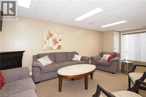Carpeted common room featuring a drop ceiling and a fireplace - 645 St. David Street S Unit# 412, Fergus, ON - Indoor