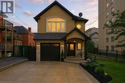 View of front of home featuring concrete driveway, stucco siding, an attached garage, and stone siding - 