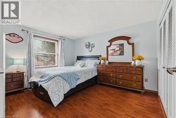 Bedroom with a textured ceiling, dark wood-style flooring, and a closet - 