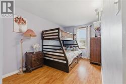 Bedroom with light wood-type flooring and a textured ceiling - 