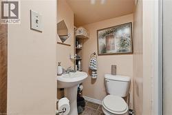 Half bathroom with toilet and tile patterned flooring - 