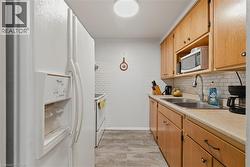 Kitchen with white appliances, light countertops, and tasteful backsplash - 