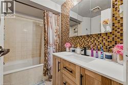 Full bathroom with tiled shower / bath, vanity, decorative backsplash, and tile walls - 