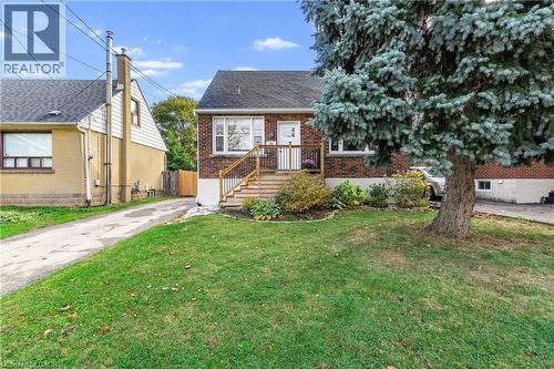 View of front facade featuring brick siding and roof with shingles - 191 East 11Th Street, Hamilton, ON - Outdoor