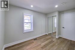Unfurnished bedroom featuring light wood-type flooring, a closet, and recessed lighting - 
