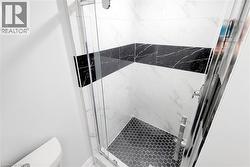 Full bathroom featuring a marble finish shower and toilet - 