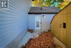 Doorway to property featuring a shingled roof and a patio - 