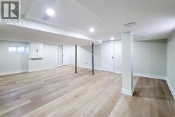 Below grade area with light wood-type flooring and baseboards - 
