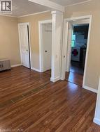Unfurnished bedroom featuring dark wood-type flooring, a textured ceiling, ornamental molding, and a closet - 