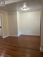 Unfurnished room with dark wood-type flooring and baseboards - 