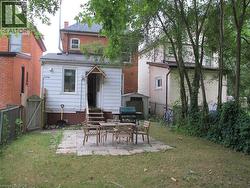 Back of house with a gate, a fenced backyard, a patio, roof with shingles, and entry steps - 