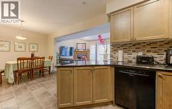 Kitchen with black dishwasher, a peninsula, open floor plan, dark stone counters, and a textured ceiling - 