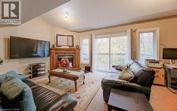 Carpeted living area with vaulted ceiling and a tiled fireplace - 