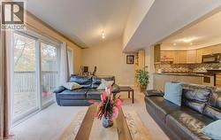 Living area featuring light colored carpet and vaulted ceiling - 