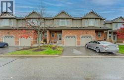 View of front of property with brick siding, driveway, and a garage - 