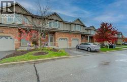 View of front facade with driveway, brick siding, and a garage - 