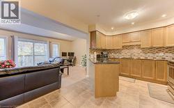 Kitchen featuring open floor plan, decorative backsplash, stainless steel range, recessed lighting, and light tile patterned floors - 