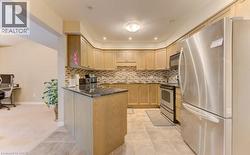 Kitchen with stainless steel appliances, tasteful backsplash, light tile patterned floors, a peninsula, and recessed lighting - 