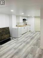 Kitchen with white cabinets, light wood-type flooring, white fridge, butcher block countertops, and recessed lighting - 