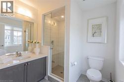 Full bathroom with a shower stall, vanity, and light tile patterned flooring - 