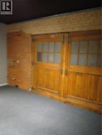 Empty room with brick wall, carpet floors, and wooden walls - 