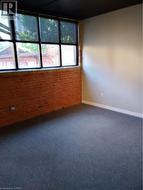 Empty room featuring brick wall and dark carpet - 