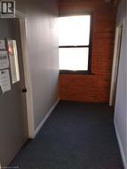 Hallway with brick wall and dark colored carpet - 
