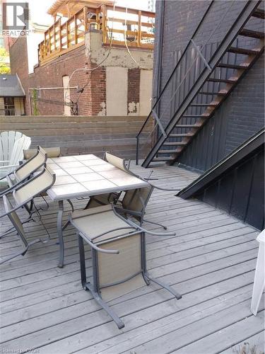 Wooden terrace with outdoor dining area and stairway - 12 Ferguson Avenue N, Hamilton, ON 